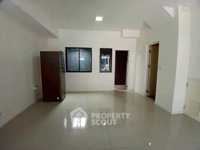 Spacious unfurnished room with tiled flooring and large window, ideal for customization.