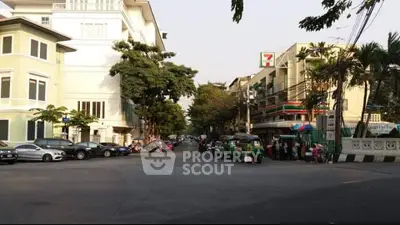 Charming urban street view with residential buildings and local shops, ideal for city living.