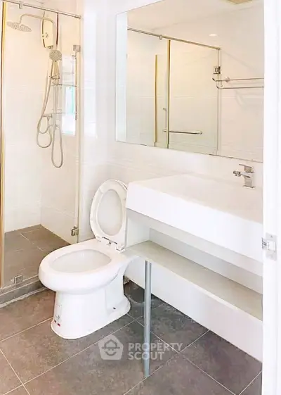 Modern bathroom with sleek fixtures and glass shower enclosure in a contemporary apartment.