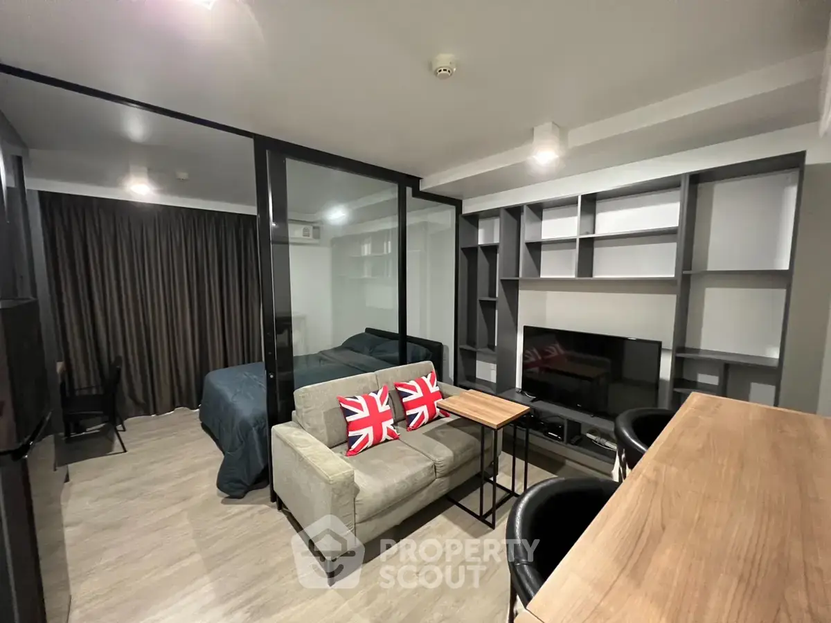 Modern studio apartment with stylish living area and glass partitioned bedroom