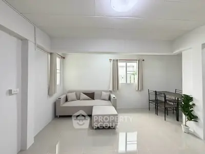 Spacious living room with modern furniture and dining area in a bright, open layout.