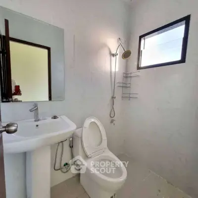 Modern bathroom with sleek fixtures and natural light from window.
