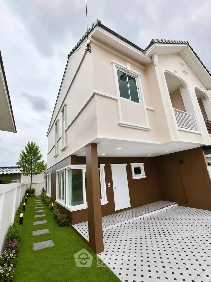 Elegant two-story house with modern design and spacious driveway, surrounded by lush greenery and stylish exterior.
