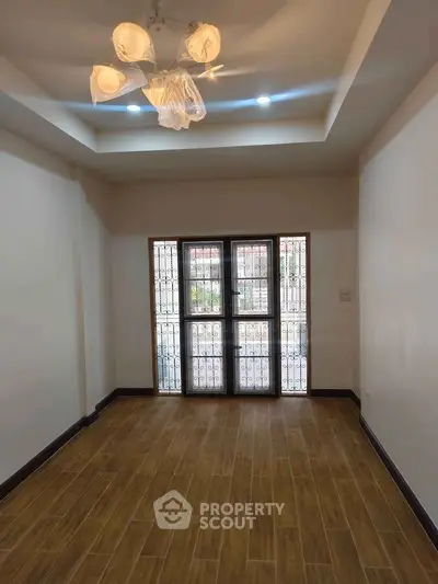 Spacious living room with elegant lighting and large window for natural light.