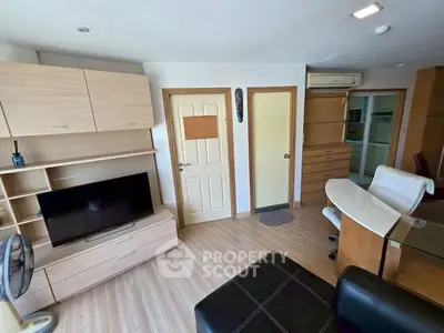 Modern living room with sleek furniture and TV, featuring light wood accents and open layout.