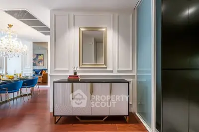 Elegant dining area with chandelier and modern sideboard in luxurious apartment