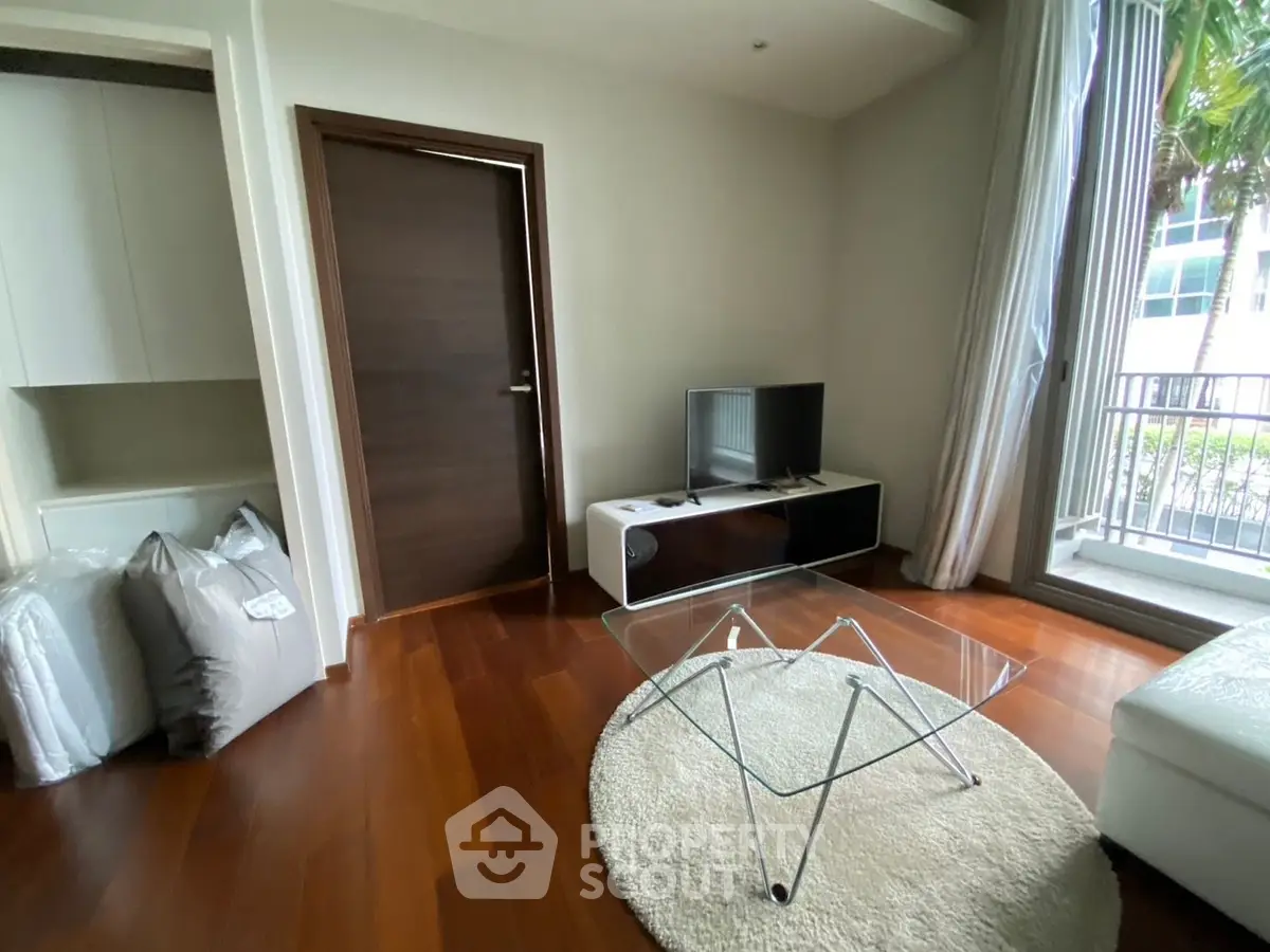 Modern living room with sleek glass coffee table and large window view