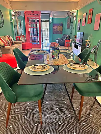 Stylish living room with vibrant decor and modern dining area, featuring a unique telephone booth accent.