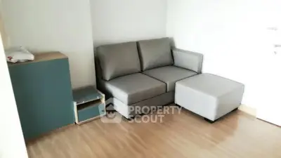 Cozy living room with modern gray sofa and wooden flooring