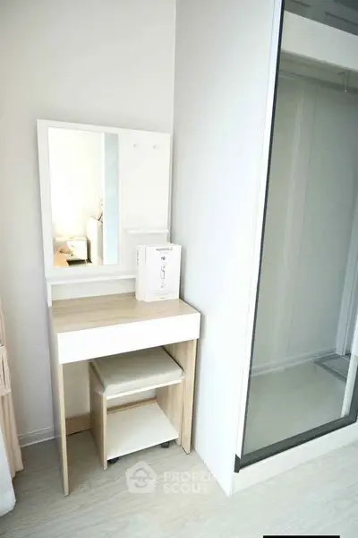 Modern minimalist bedroom with sleek vanity and sliding glass door closet