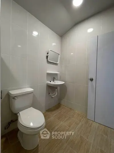 Modern bathroom with sleek white tiles and compact fixtures for a minimalist design.