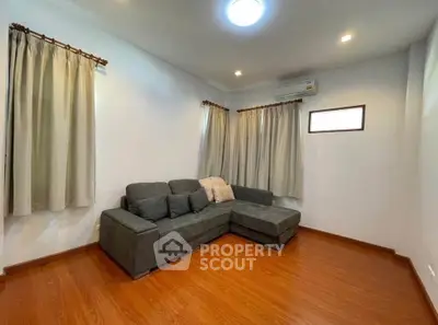 Cozy living room with wooden flooring and modern gray sectional sofa.