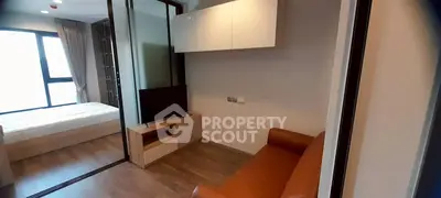 Modern apartment interior with cozy living room and bedroom, featuring sleek furniture and natural light.