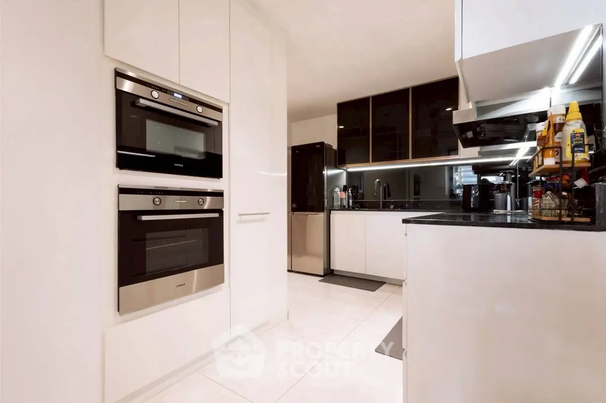 Modern kitchen with sleek appliances and glossy cabinets in a contemporary home.