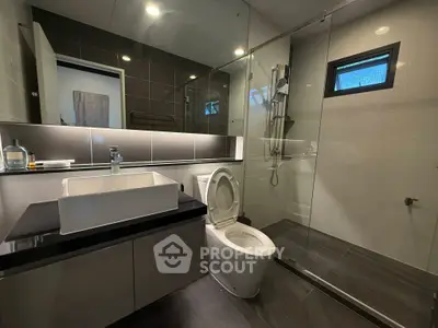 Modern bathroom with sleek design, glass shower, and stylish fixtures.