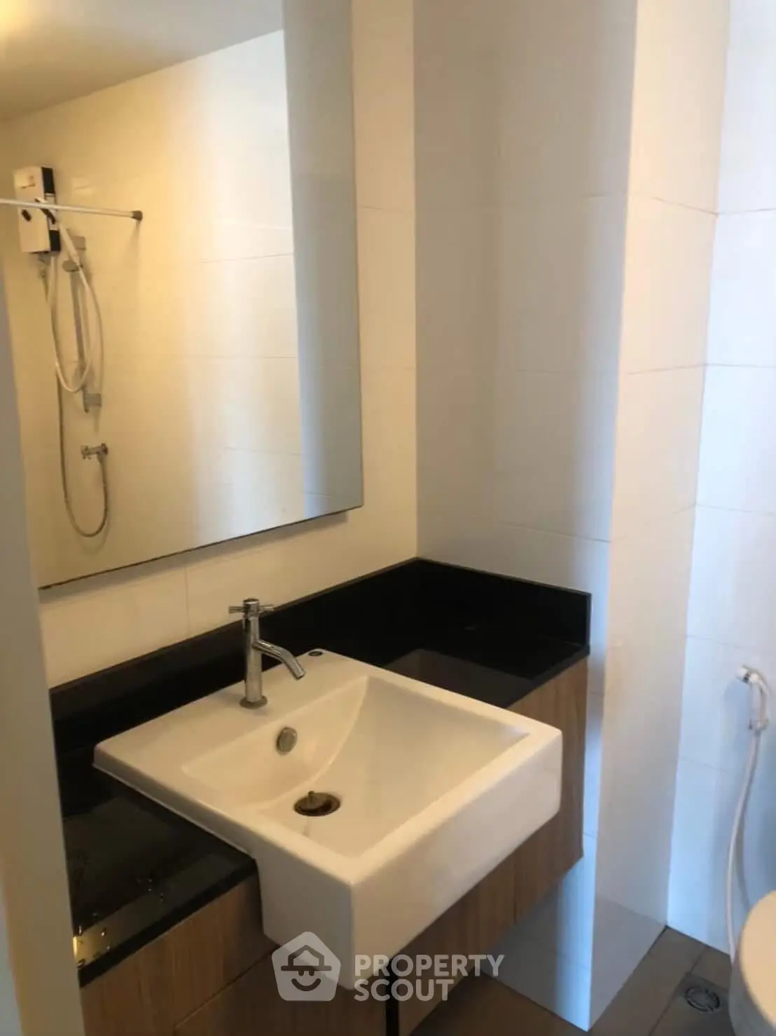 Modern bathroom with sleek sink and shower in contemporary apartment.