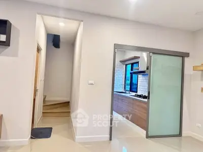 Modern kitchen with sliding glass door and wooden cabinets in a bright interior space.