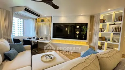 Luxurious living room with modern decor and large TV, perfect for relaxation and entertainment.