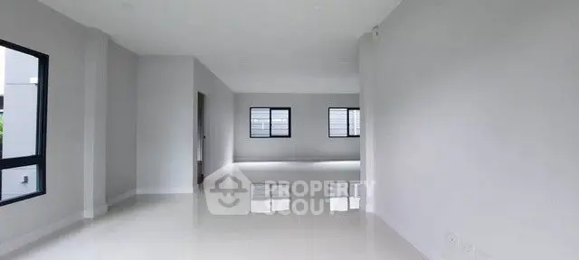 Spacious modern interior with sleek white flooring and large windows, perfect for customization.