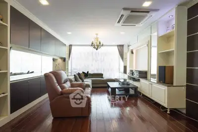 Spacious living room with elegant chandelier and modern furniture, perfect for relaxation and entertainment.