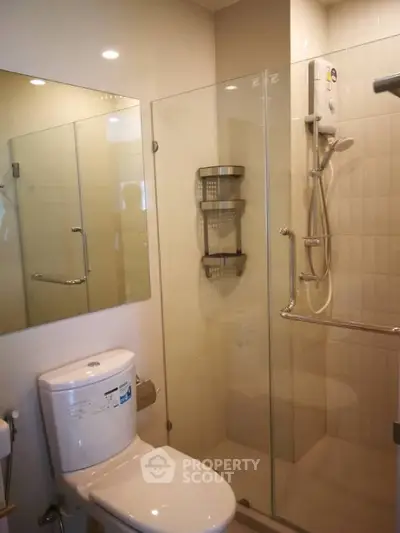 Modern bathroom with glass shower enclosure and sleek fixtures.