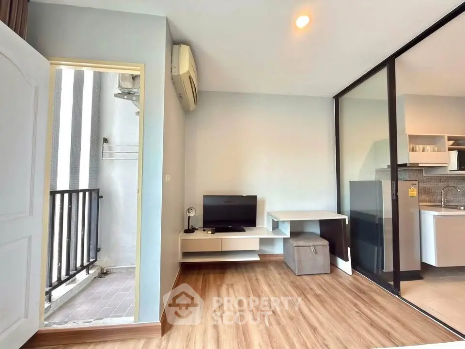 Modern living room with wooden flooring and balcony access
