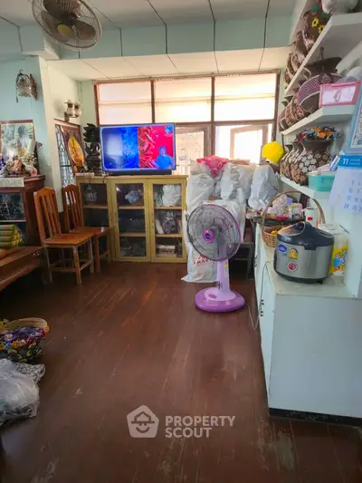 Cozy living room with wooden floors, TV, and eclectic decor, perfect for relaxation and entertainment.
