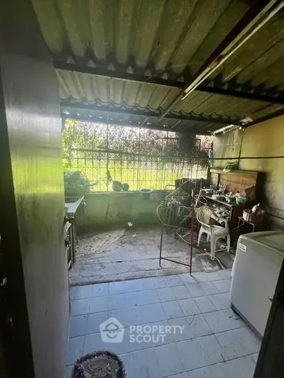 Rustic outdoor kitchen with corrugated roof and garden view