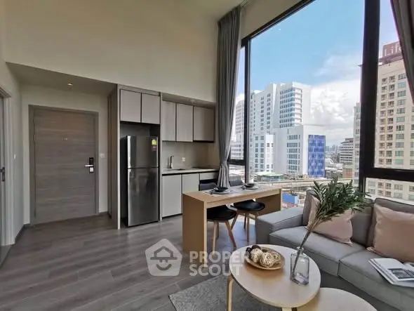 Modern open-plan living room with city view, featuring sleek kitchen and dining area.