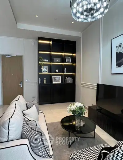 Elegant living room with modern decor, featuring a stylish black shelving unit and cozy seating area.