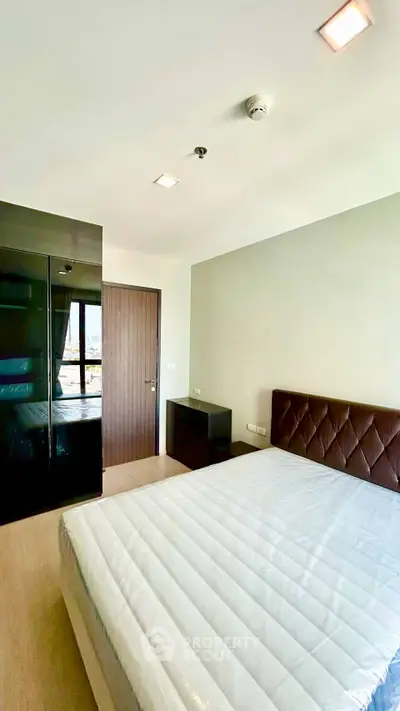 Modern bedroom with sleek design and natural light, featuring a comfortable bed and stylish furnishings.