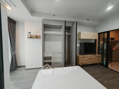 Modern bedroom with open wardrobe and sleek furnishings in a stylish apartment.