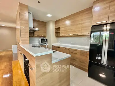 Modern kitchen with sleek wooden cabinets and black appliances