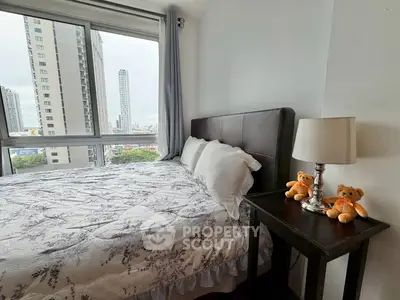 Cozy bedroom with city view, featuring plush bedding and charming teddy bear decor.