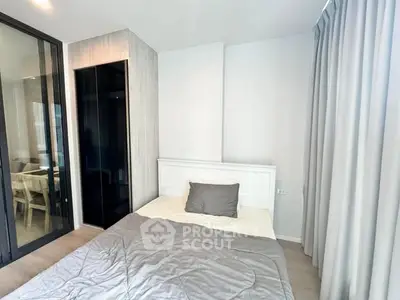 Modern bedroom with sleek design and glass partition, featuring a cozy bed and stylish decor.