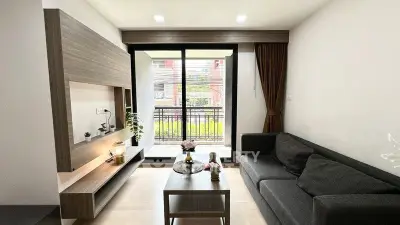 Modern living room with sleek furniture and balcony view in a stylish apartment.
