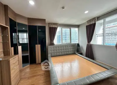 Spacious bedroom with modern design and large windows offering city views.