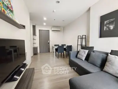 Modern living room with sleek furniture and wall-mounted TV in a stylish apartment.