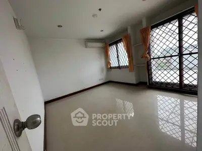 Spacious empty room with large windows and natural light, ideal for customization.