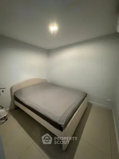 Cozy minimalist bedroom with modern bed and soft lighting, perfect for relaxation.