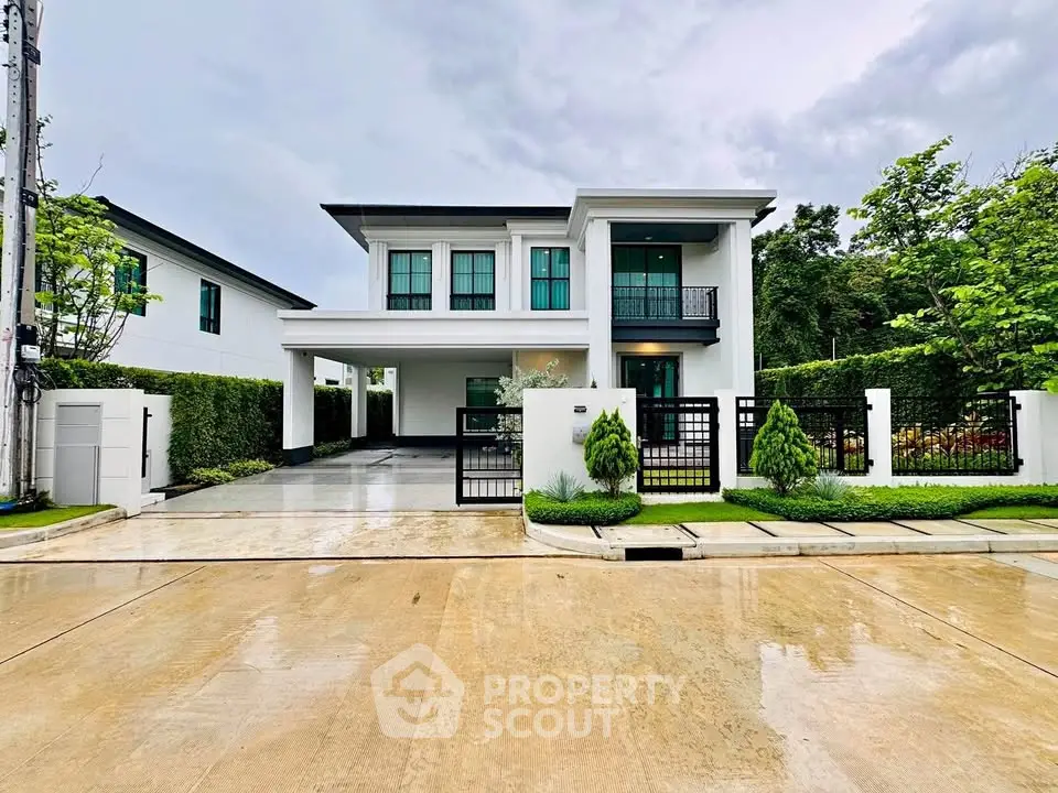 Modern two-story house with sleek design and lush greenery in a serene neighborhood.