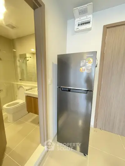 Modern apartment interior with sleek refrigerator and bathroom view
