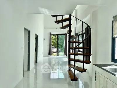 Modern interior with spiral staircase and large windows offering natural light and garden view.