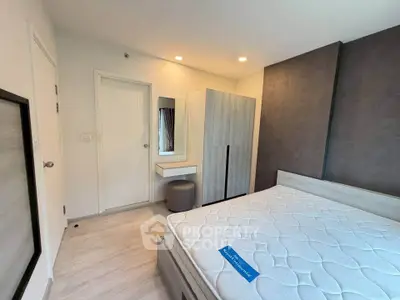 Modern bedroom with stylish decor and ample natural light, featuring a comfortable bed and sleek wardrobe.