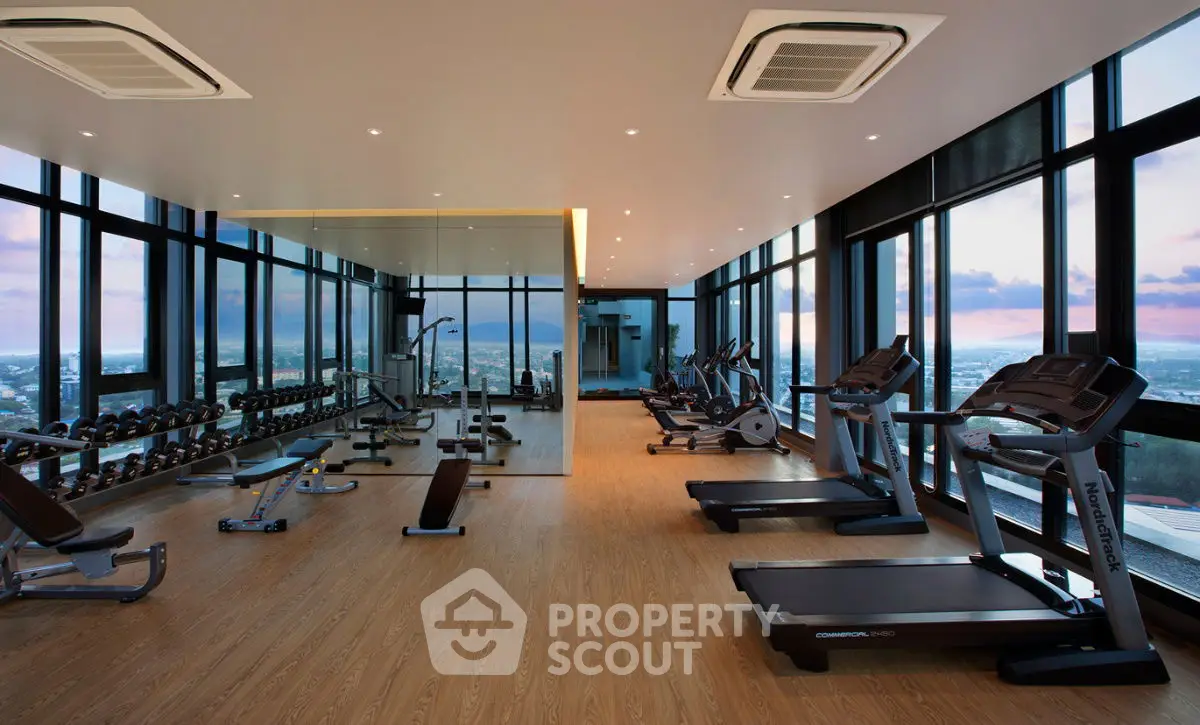 Luxurious high-rise gym with panoramic city views and modern fitness equipment.