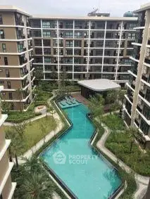 Luxurious apartment complex with stunning pool and lush garden view.