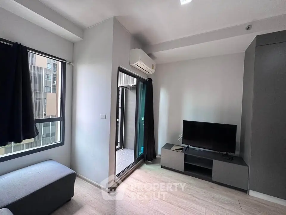 Modern living room with balcony access and sleek furniture in urban apartment