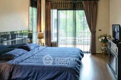 Spacious bedroom with elegant decor and large windows offering natural light.