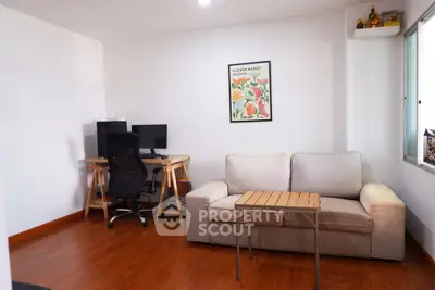 Cozy living room with sofa, desk, and computer setup, perfect for work and relaxation.
