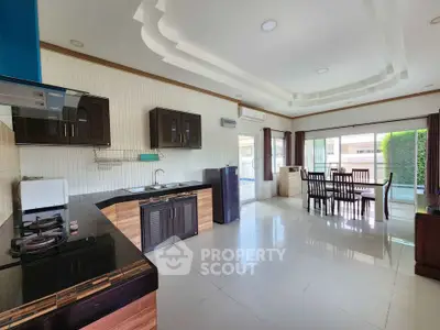 Spacious open-layout kitchen and dining area with modern appliances and large windows.
